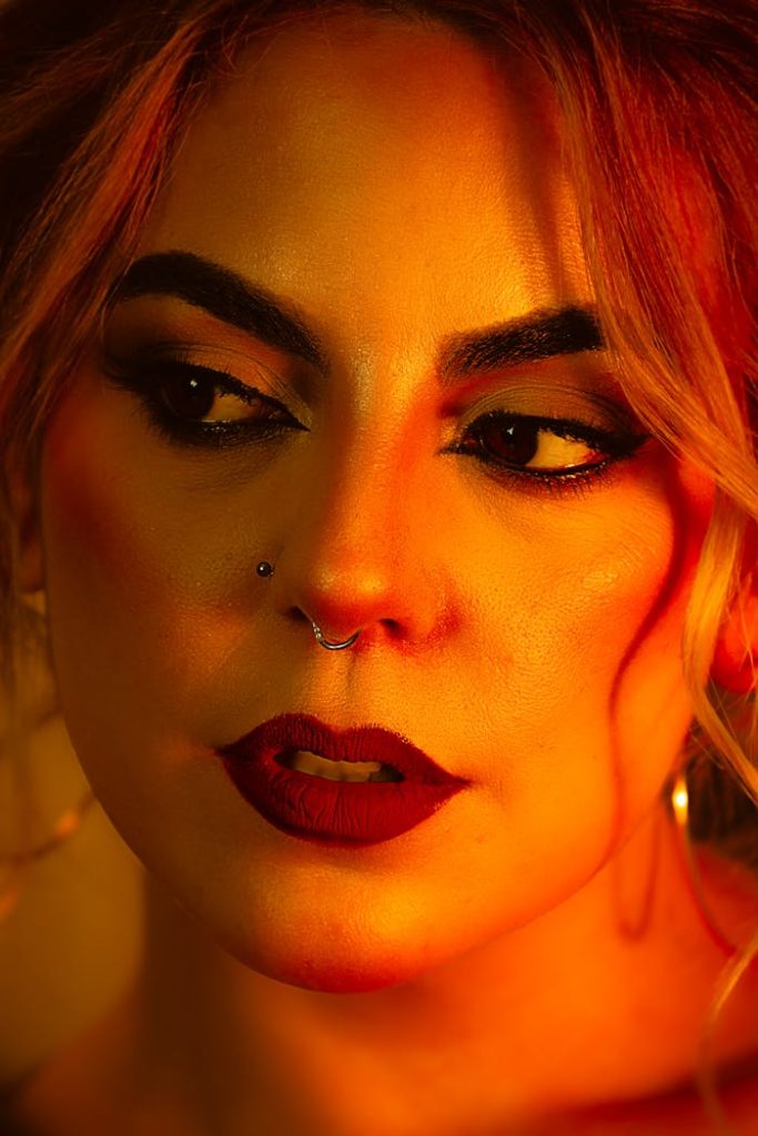 Close-up portrait of an elegant woman with warm lighting highlighting her features.